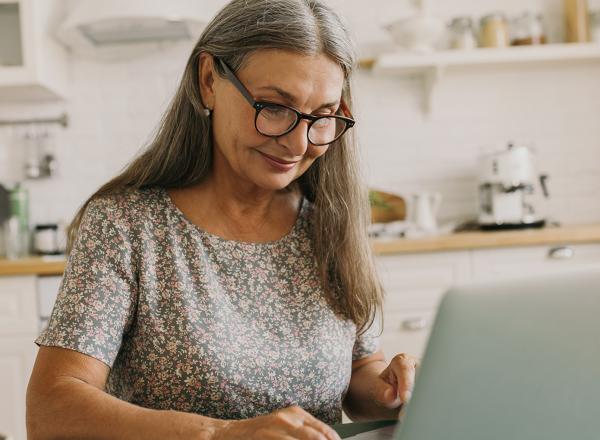 Woman looking at laptop in kitchen